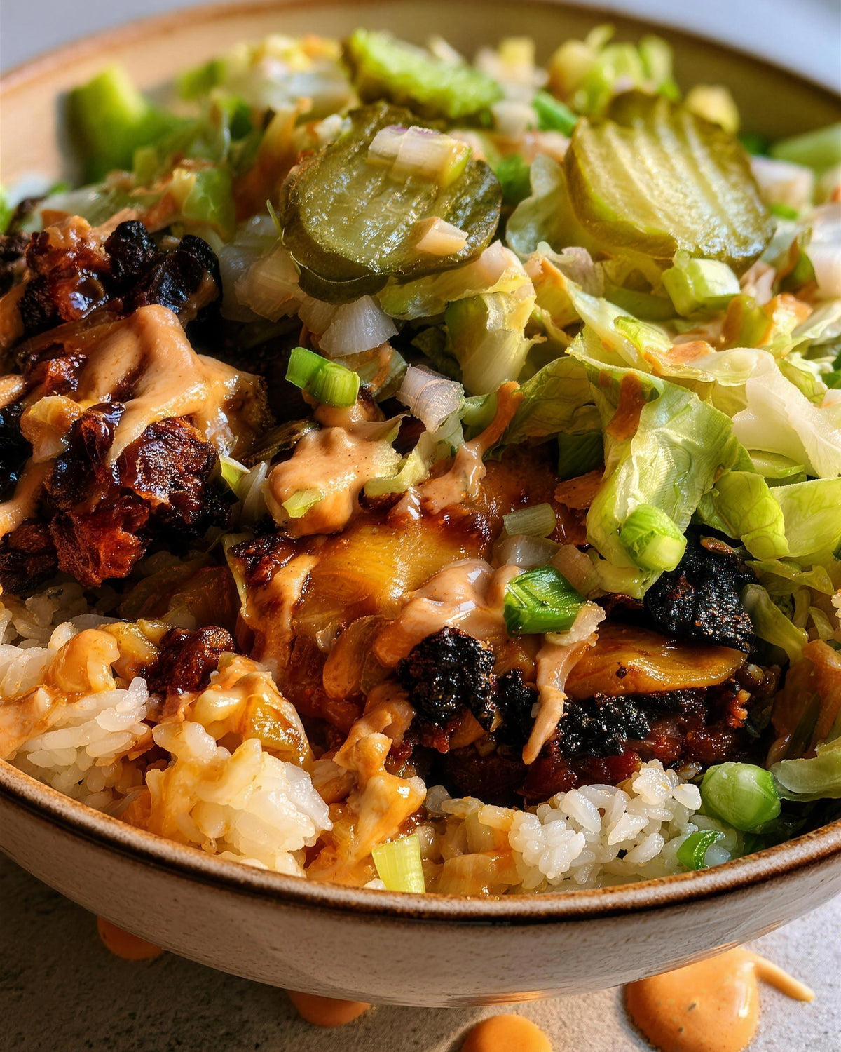 Low carb smash burger rice bowl with cheesy smash patties, pickles, lettuce and orange special sauce over Qetoe Rice